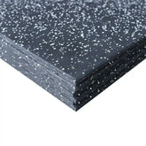 Stack of black rubber mats with white flecks on a white background